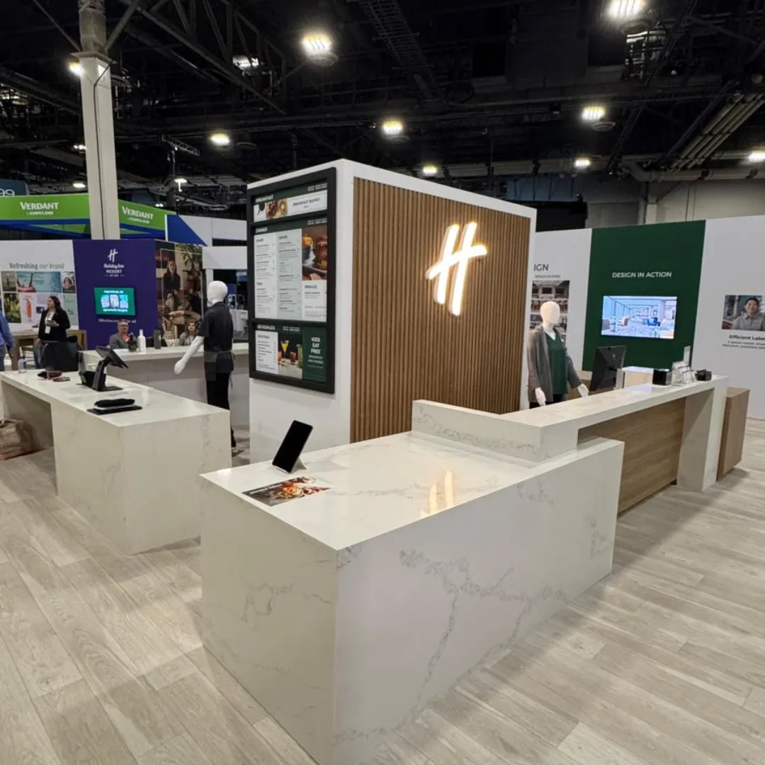 Tradeshow booth featuring a custom quartz counter with a sleek, modern design, wood panel accents, and illuminated branding.