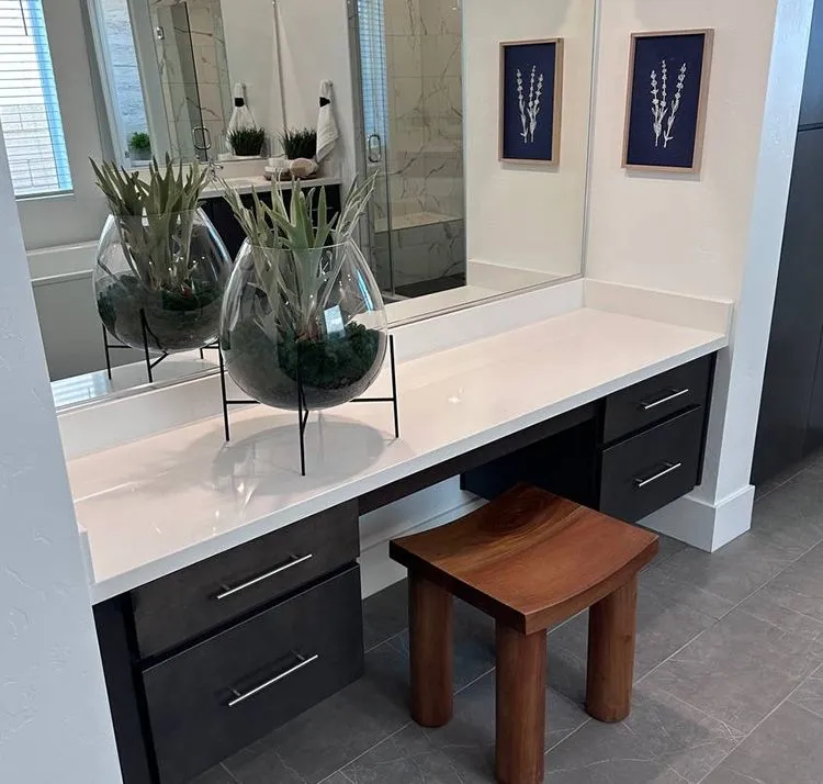 Modern bathroom vanity with white stone countertop and dark cabinetry