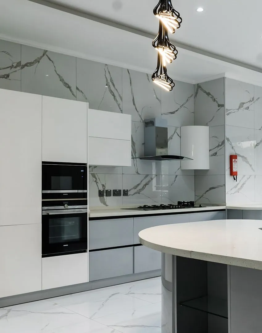Modern kitchen with a marble backsplash and range hood